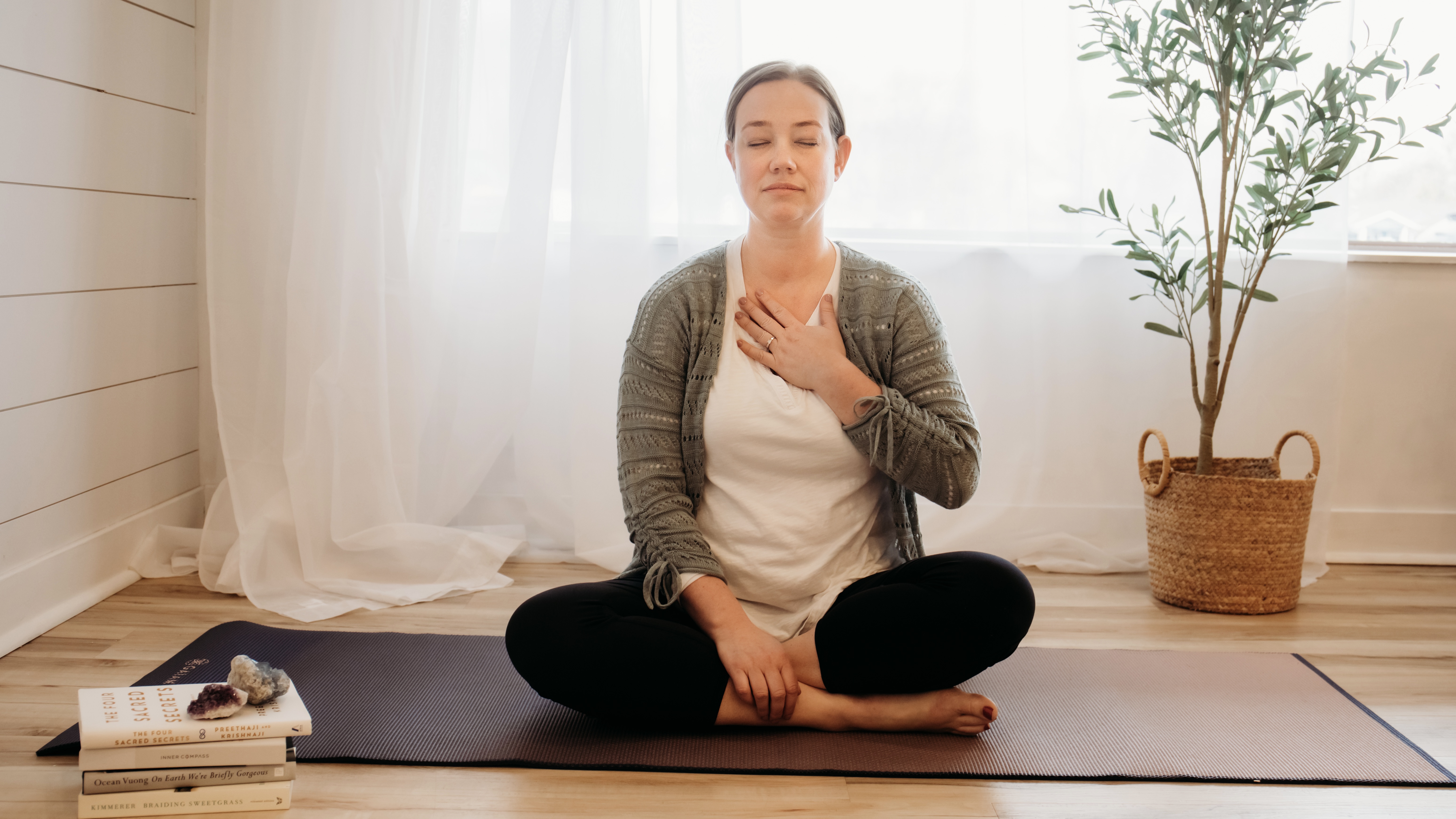 Person sitting in a meditative posture, practicing deep breathing exercises