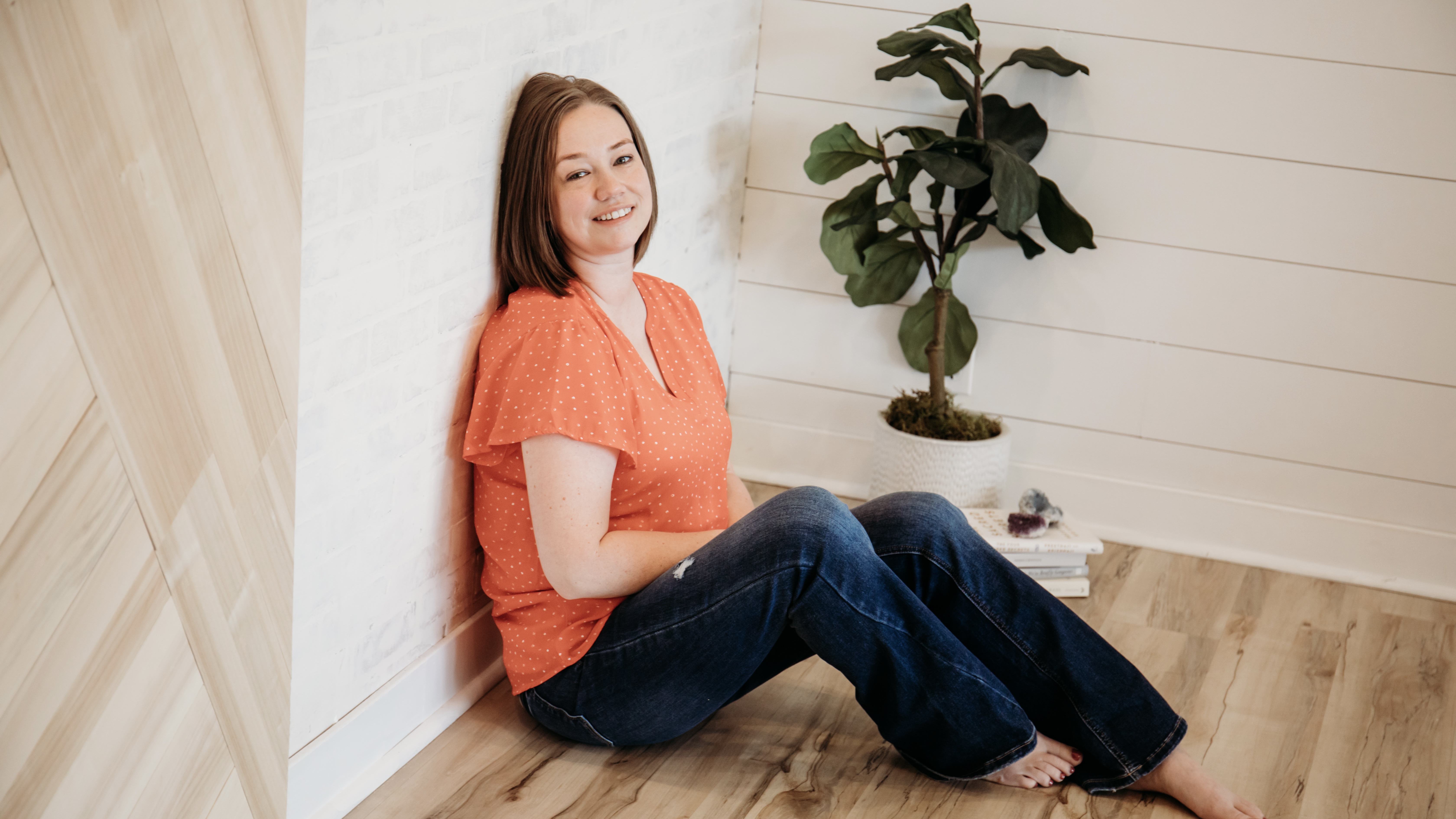 Sonya is leaning against a wall smiling