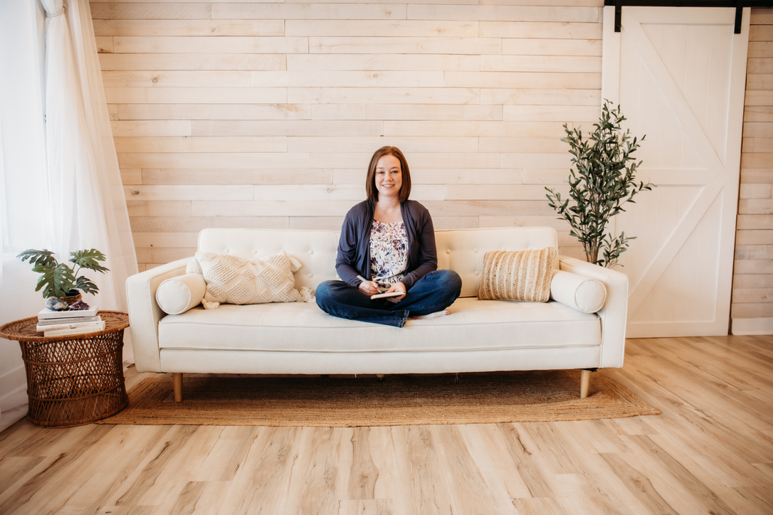 Woman sitting on couch with a journal